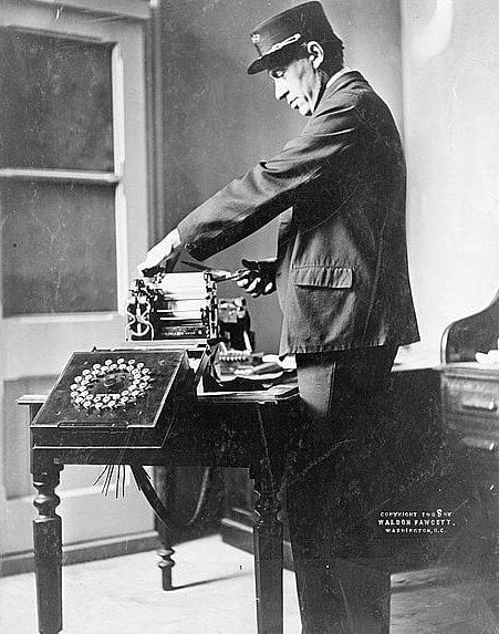 Operador de telégrafo cortando un telegrama 