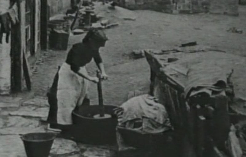 Mujer lavando con un “washing dolly”