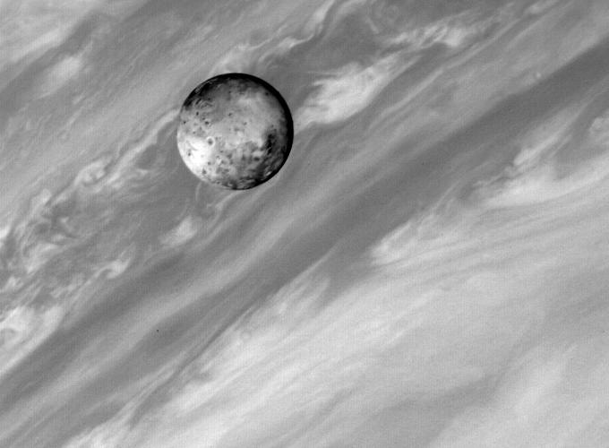 Ío, fotografiada por la Voyager 1 con Júpiter al fondo.
